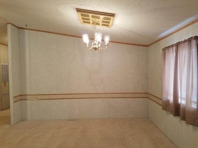 empty room with an inviting chandelier, crown molding, and carpet floors