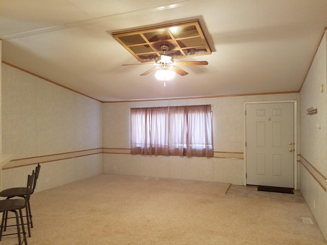 carpeted empty room with crown molding and ceiling fan