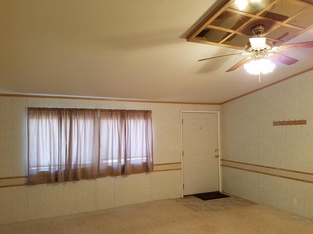 carpeted empty room featuring lofted ceiling, plenty of natural light, and ceiling fan