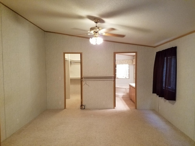 unfurnished room featuring light carpet, ceiling fan, a textured ceiling, and lofted ceiling