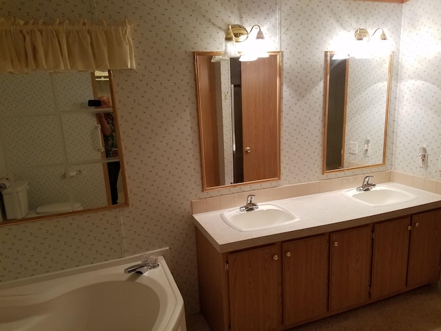 bathroom featuring a washtub, large vanity, and double sink