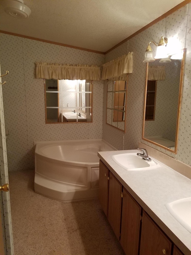 bathroom featuring a textured ceiling, dual bowl vanity, and a bath to relax in