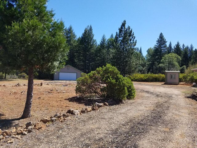 view of yard featuring an outdoor structure and a garage