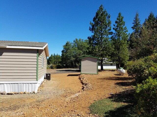 view of yard with a shed and central AC unit