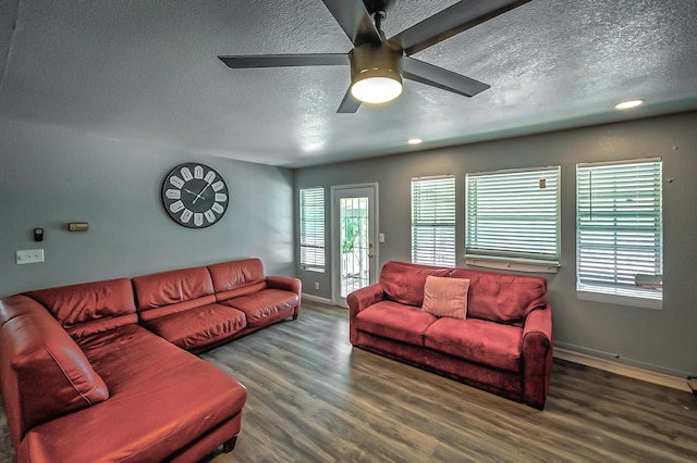 living room with ceiling fan, dark wood-type flooring, and a textured ceiling