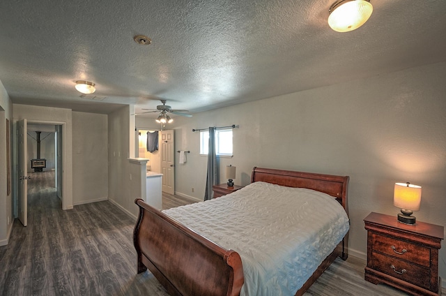 bedroom with ceiling fan, dark hardwood / wood-style flooring, ensuite bath, and a textured ceiling