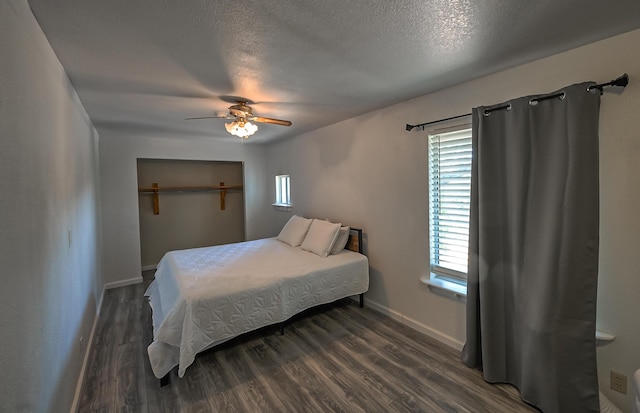 bedroom featuring ceiling fan, dark hardwood / wood-style flooring, and a textured ceiling