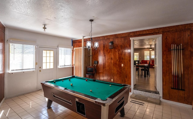 recreation room with light tile patterned floors, pool table, a textured ceiling, and wood walls