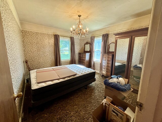 bedroom featuring an inviting chandelier and dark colored carpet