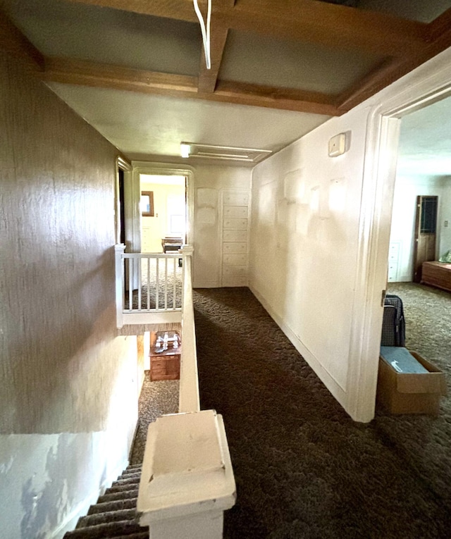 hallway with beamed ceiling and dark colored carpet