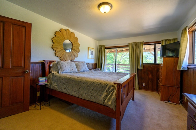 carpeted bedroom featuring wooden walls