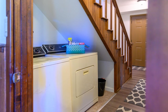 laundry room featuring separate washer and dryer and light hardwood / wood-style flooring