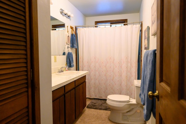 bathroom featuring walk in shower, vanity, and toilet