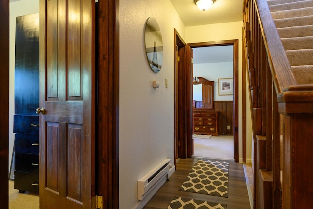 corridor with hardwood / wood-style flooring, baseboard heating, and wooden walls