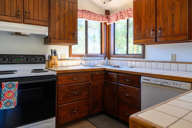 kitchen featuring tile countertops, plenty of natural light, and white appliances