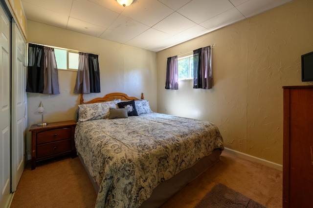 bedroom featuring light carpet and a closet