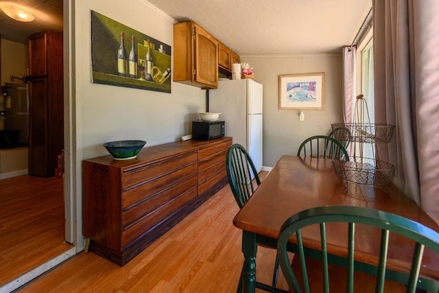 dining room featuring light wood-type flooring and ornamental molding