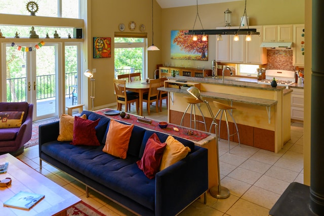 living room featuring light tile patterned floors, high vaulted ceiling, and a wealth of natural light