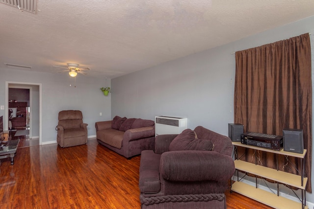 living room featuring a textured ceiling, heating unit, ceiling fan, and dark wood-type flooring