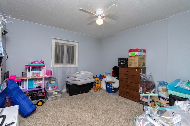 game room featuring carpet flooring, a textured ceiling, and ceiling fan