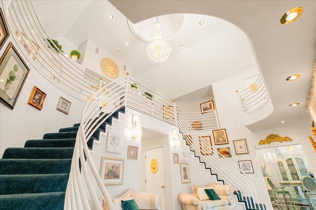 staircase featuring a towering ceiling and a notable chandelier