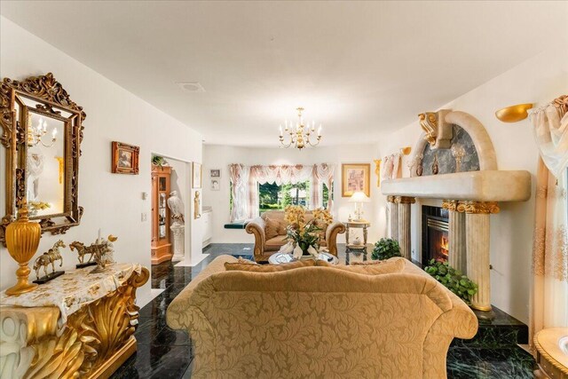 living room with an inviting chandelier and a premium fireplace