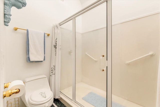 bathroom with toilet and a shower with shower door