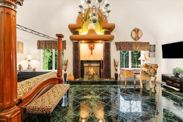 bedroom featuring a fireplace, multiple windows, and lofted ceiling