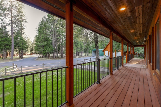 wooden terrace featuring a lawn