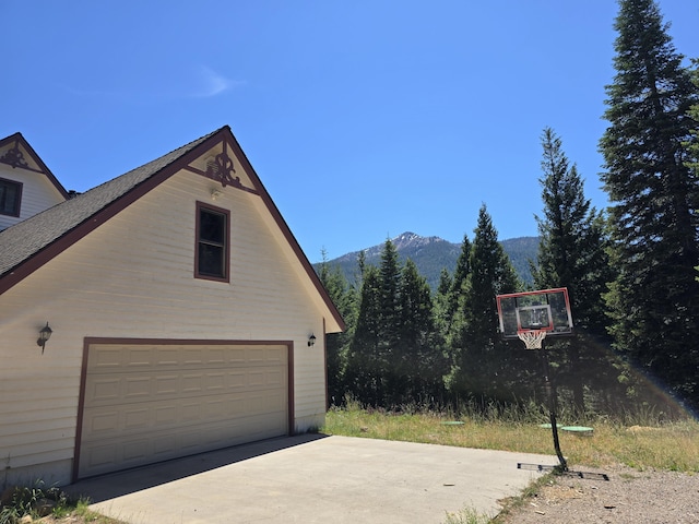 view of home's exterior featuring a garage, a mountain view, and an outdoor structure