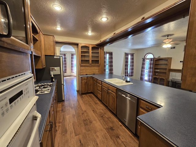 kitchen with stainless steel dishwasher, sink, gas cooktop, and a textured ceiling