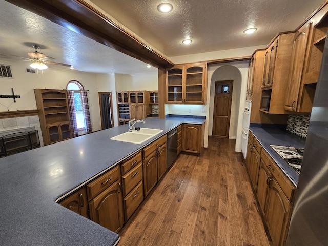 kitchen with sink, decorative backsplash, ceiling fan, a textured ceiling, and dark hardwood / wood-style flooring