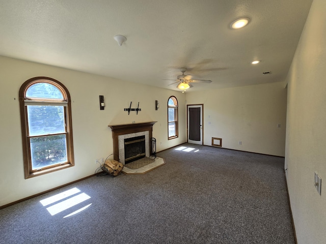 unfurnished living room with dark carpet and ceiling fan