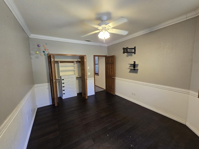 unfurnished bedroom featuring ceiling fan, dark hardwood / wood-style flooring, ornamental molding, and a closet