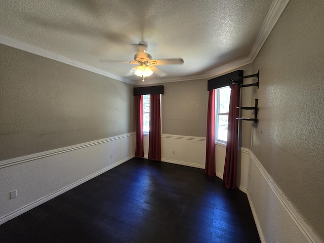 unfurnished room with a textured ceiling, ceiling fan, ornamental molding, and dark wood-type flooring