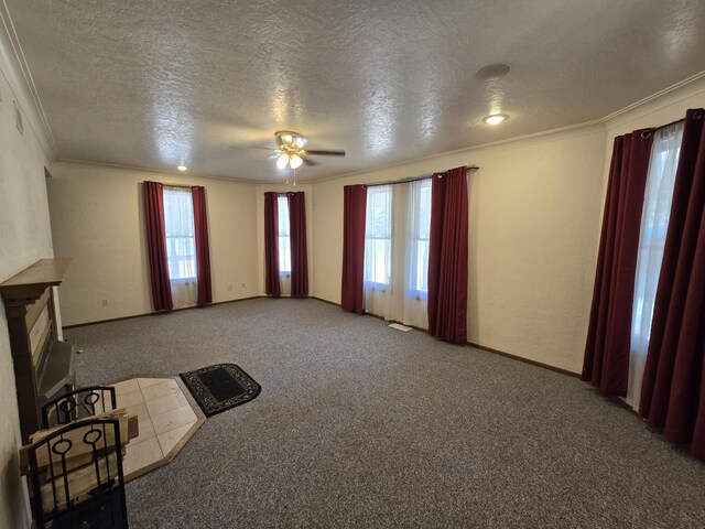 unfurnished living room with carpet flooring, a textured ceiling, a wealth of natural light, and ornamental molding