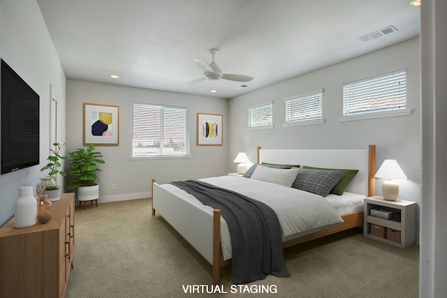 carpeted bedroom featuring multiple windows and ceiling fan