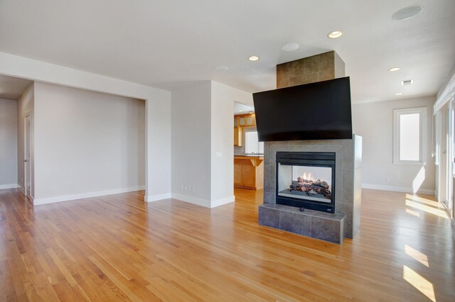 unfurnished living room featuring a fireplace and light wood-type flooring