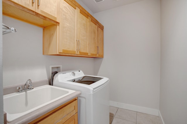 washroom featuring sink, light tile patterned floors, cabinets, and washer / dryer