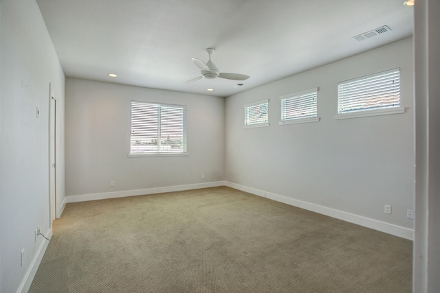 spare room with ceiling fan and light colored carpet