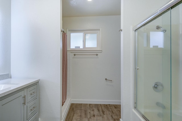 bathroom featuring baseboards, wood finished floors, and vanity
