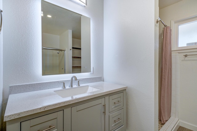 full bath with a shower stall and vanity
