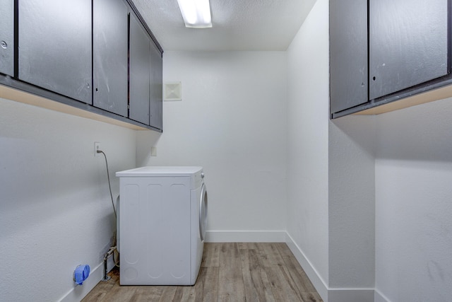 washroom with visible vents, washer / dryer, light wood-style floors, baseboards, and cabinet space