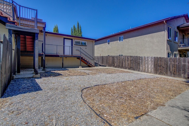 exterior space featuring a deck, fence, and stairs