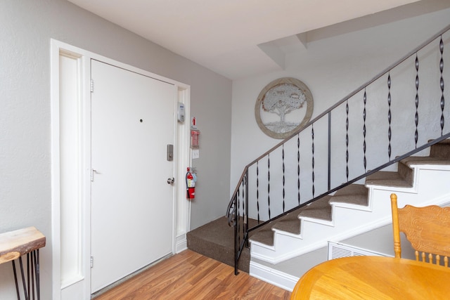 foyer with light wood-style floors and stairs
