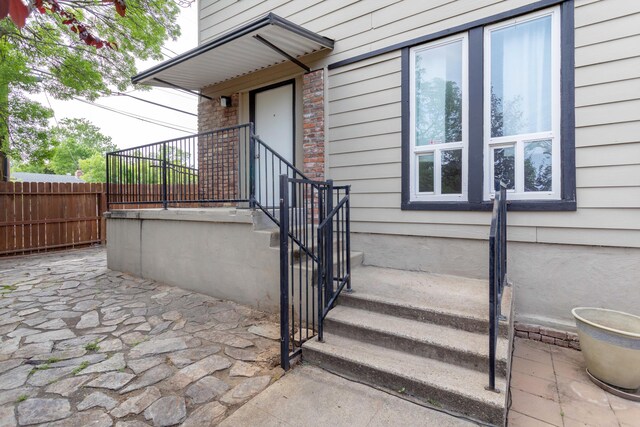 view of exterior entry featuring fence