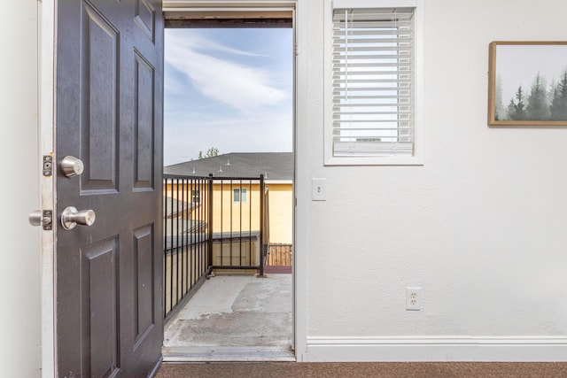 doorway to outside featuring baseboards
