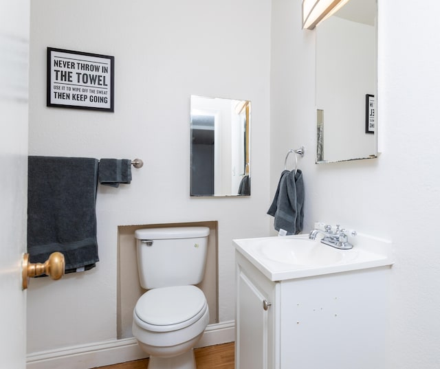 bathroom featuring vanity, baseboards, toilet, and wood finished floors