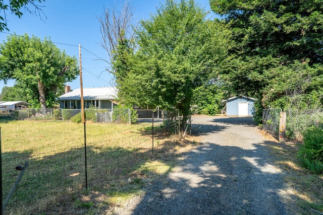 view of front of property featuring a storage shed and a front lawn