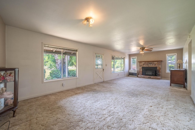 unfurnished living room featuring a fireplace, ceiling fan, and carpet flooring